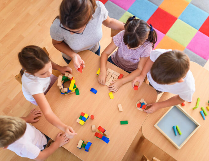 Groupe d'enfants jouant à un jeu de construction, vue de dessus.